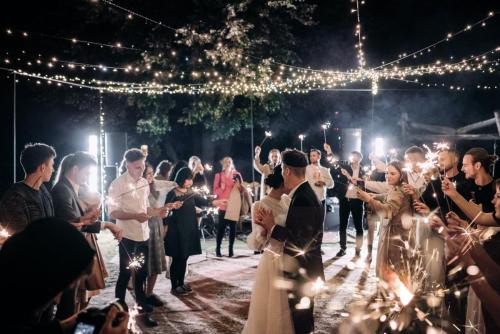 free-photo-of-wedding-guests-holding-sparklers-and-standing-around-the-newlyweds-dancing